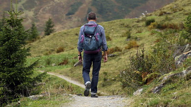 Wędrujący turysta z plecakiem na górskiej ścieżce 